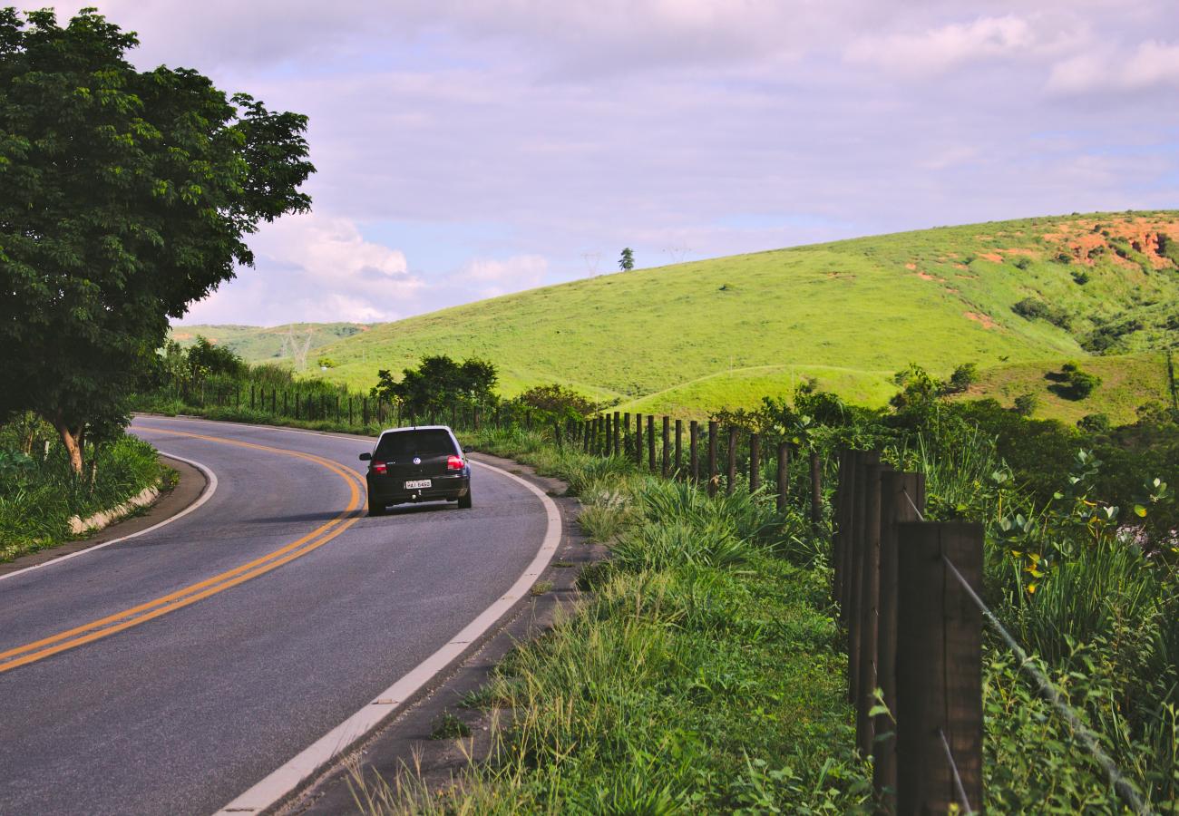 car driving through rolling green hills